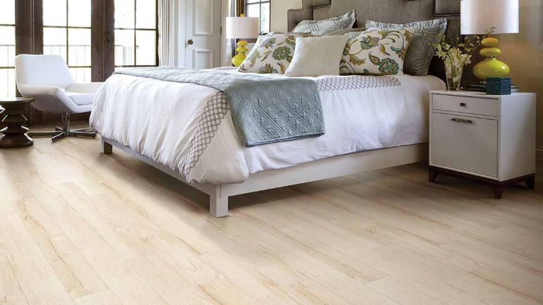 soft warm toned wood look laminate flooring in a bright bedroom